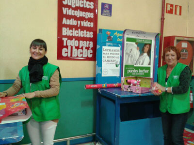 Voluntarios y voluntarias envuelven regalos a cambio de un donativo