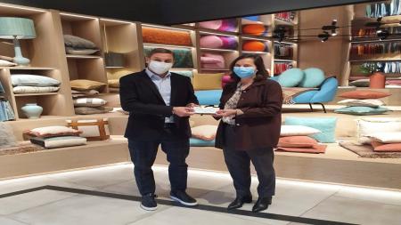 Manuel Gancedo, director general de la firma textil Gancedo, entrega simbólicamente la recaudación de la gerente de AECC Madrid, Isabel Bauluz.