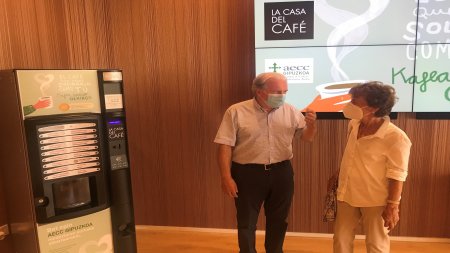 Juan Ormazabal (AECC Gipuzkoa) y Karmele Iriondo (La Casa del Café) en la firma del acuerdo de colaboración